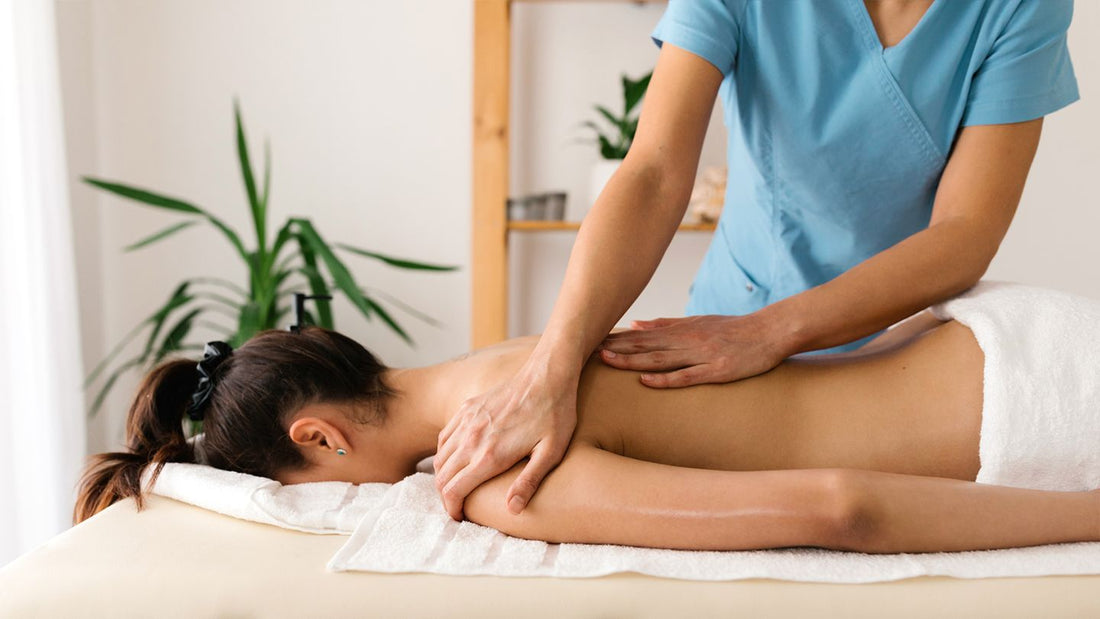 Unlocking the Healing Power of Rapid Release Technology Treatment. A young woman face down on a massage table with the massage therapists hands on her back and shoulder